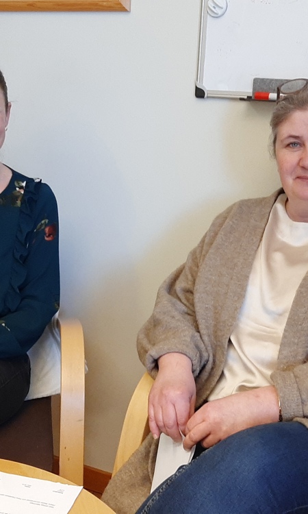 Maria Westin och Jenny Örnberg sitter ner i varsin stol med ett bord framför sig.