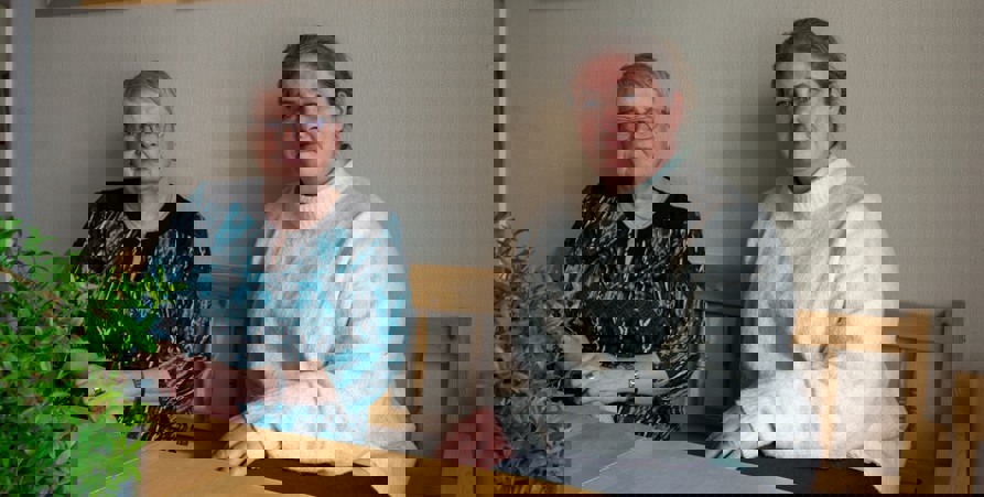 Barbro och Jenny sitter ner i en soffa. Framför sig har de ett bord med en grön växt i förgrunden.